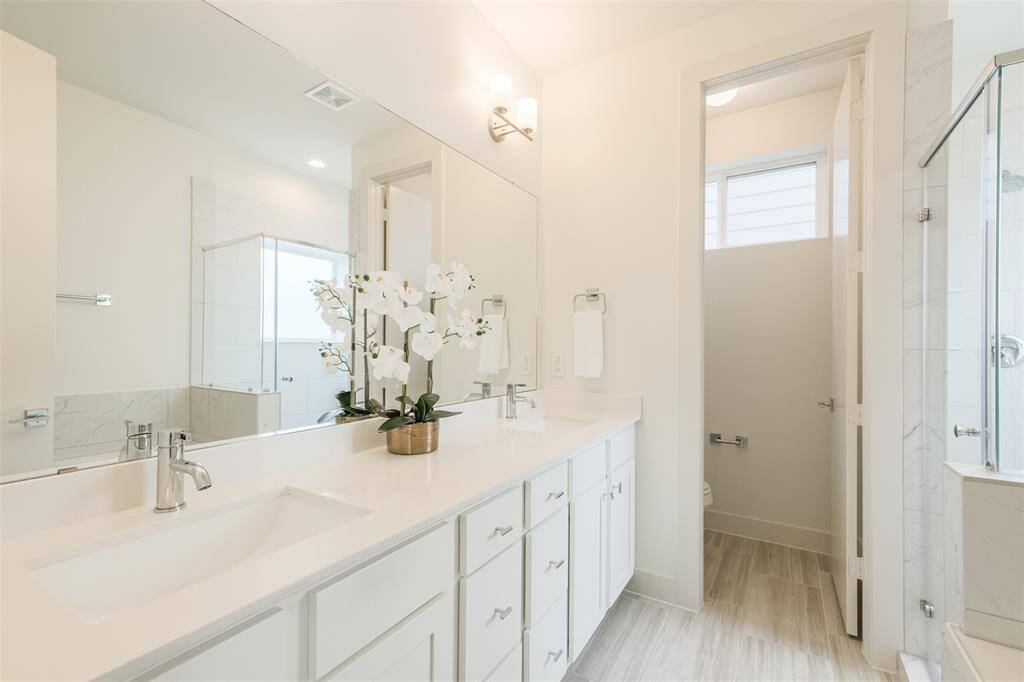 Primary Bath featuring double sink, separate shower, and separate tub .