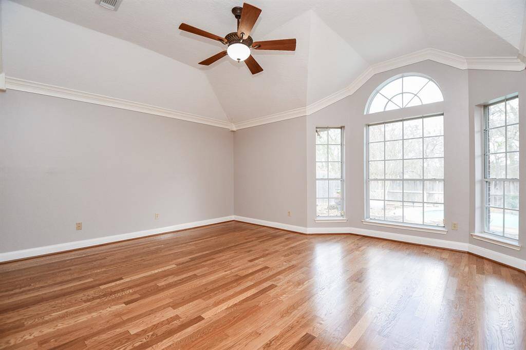 Large light and bright primary bedroom with lovely view of backyard.