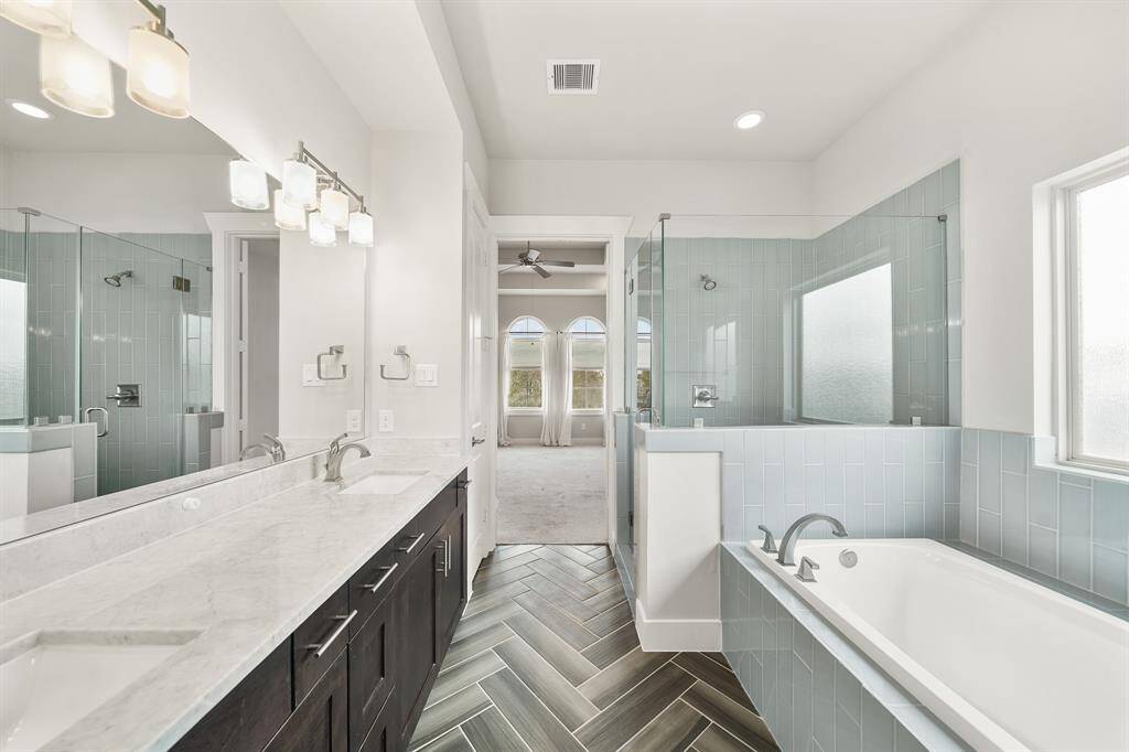A view of the owner's bedroom from the private bath. Included is a linen storage closet and access to a custom 10' x 9' walk-in wardrobe closet with floor-to-ceiling triple hung wardrobe storage areas, plenty of adjustable shelving & storage areas & carpet.