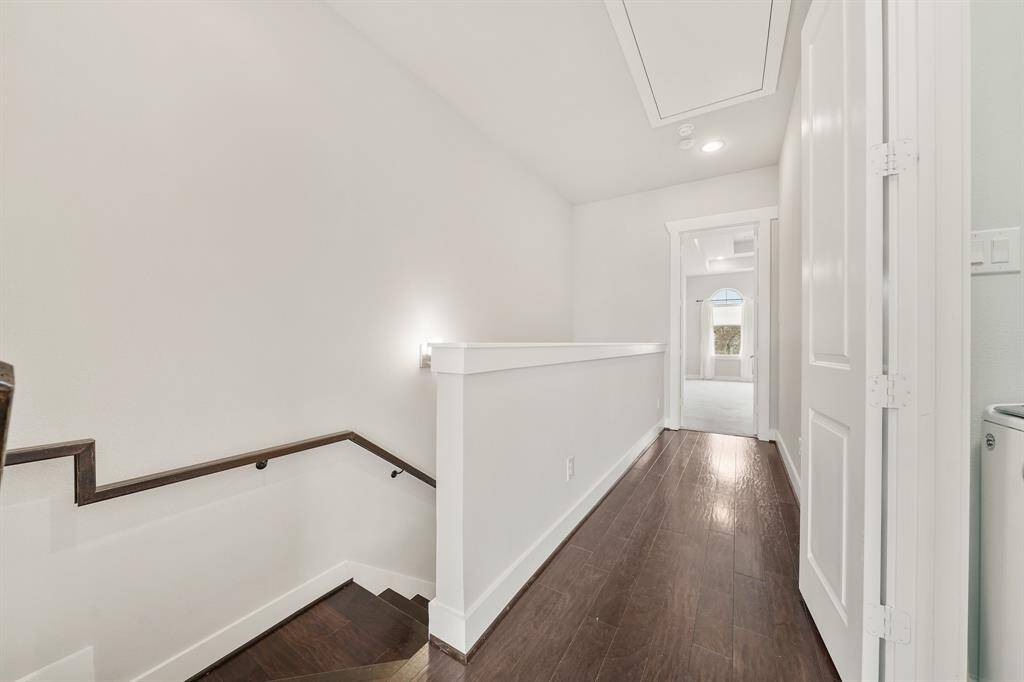 A view of the third floor corridor and secondary bedroom in the background.