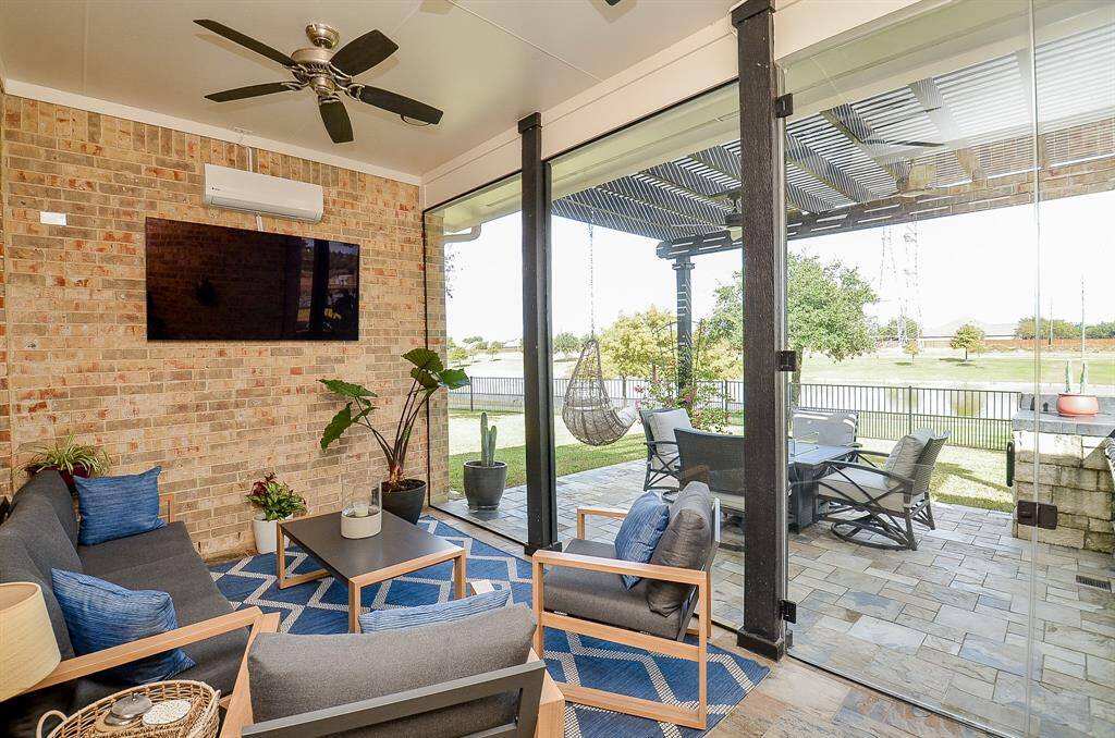One of the most outstanding features of this property is this indoor-outdoor living space.  You can enjoy the indoor covered patio with Bayshire fans and a Zokop mini-split AC unit, both installed in 2024. This outdoor patio has been enclosed in panoramic glass in order for you to comfortably enjoy this view in any weather.