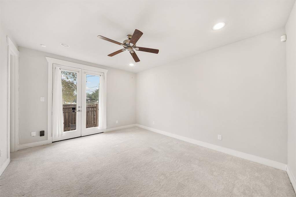 Located on the first level of the home and accessible just off the foyer, the third bedroom has recessed lighting, a ceiling fan, French doors leading to the backyard & carpet.