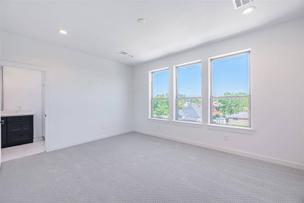 Primary bedroom with recessed lighting and large windows