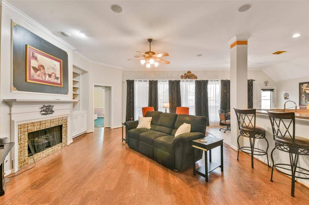 Living area offers space to spread out, along with a fireplace and a wall of windows overlooking the backyard.