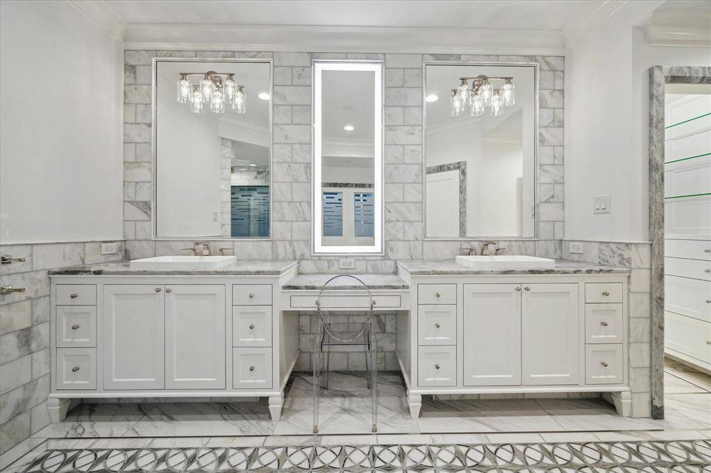 [Primary Bathroom] Luxurious bathroom boasts marble counters, dual sinks and vanity area.