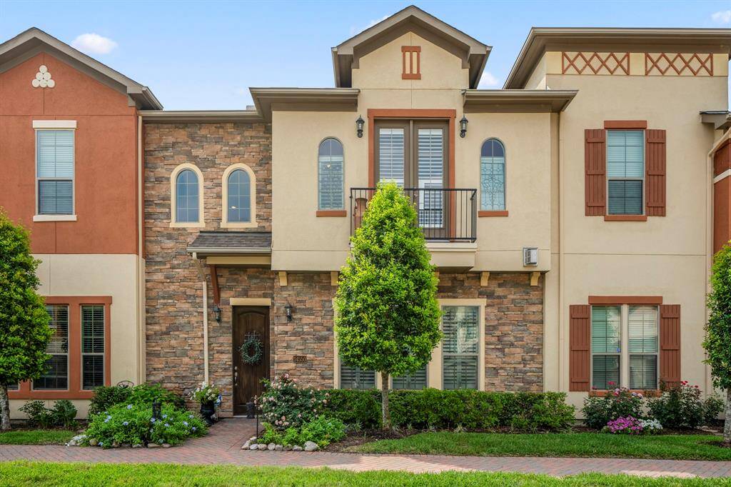 An exterior view of the home showing a rich Mediterranean architecture, with stone / brick elevation and arched windows.
