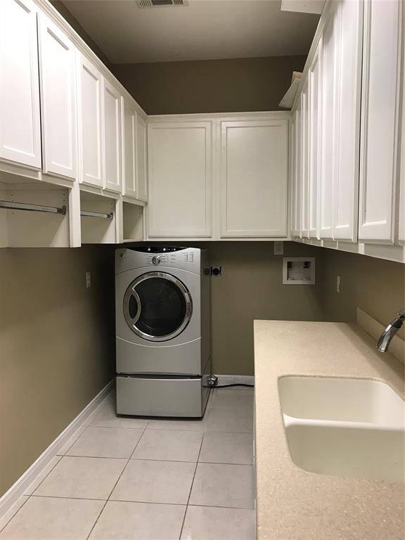 The laundry area has great cabinet and counter space.