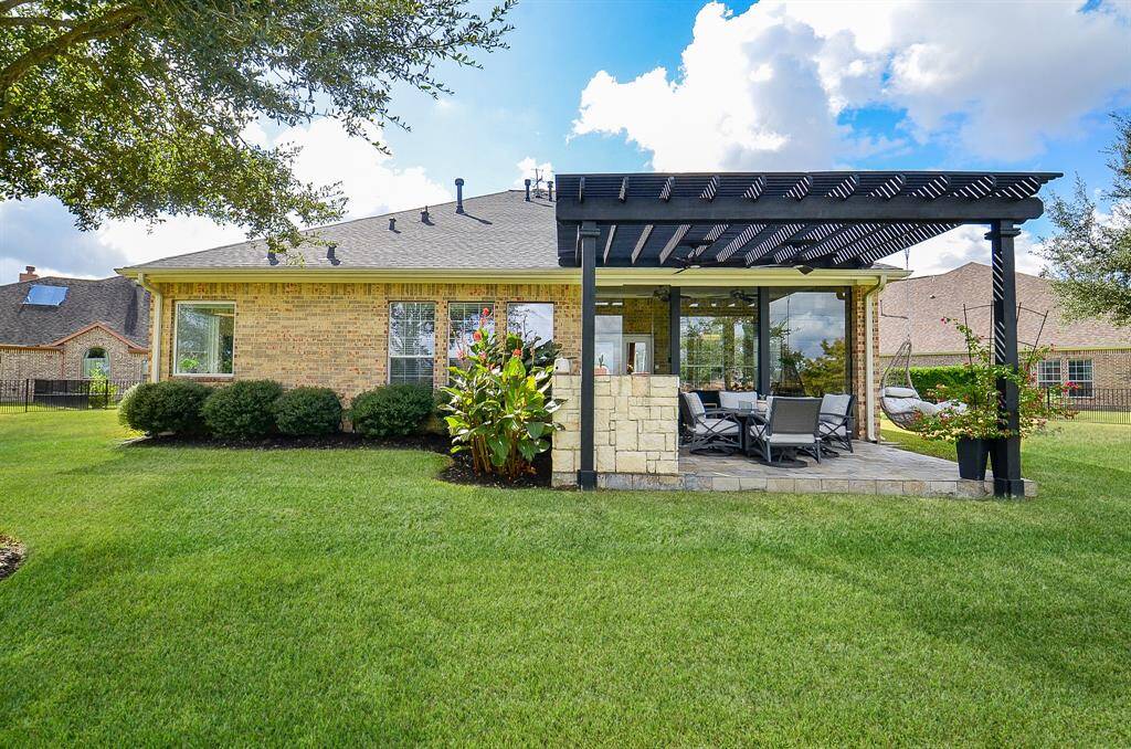 A view of the complete back of the house, with manicured flower beds and shrubbery.  Also note that you have a great deal of space between yourself and the neighbors.