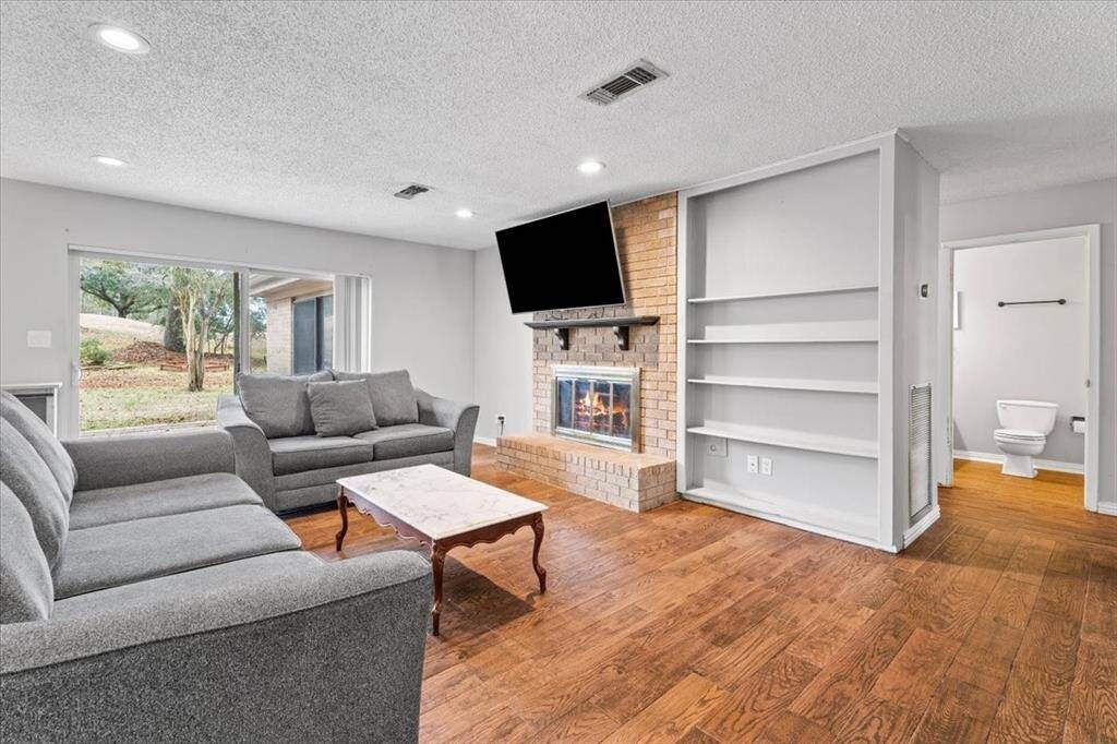Cozy living room with tasteful tile floors, large windows, and built ins.