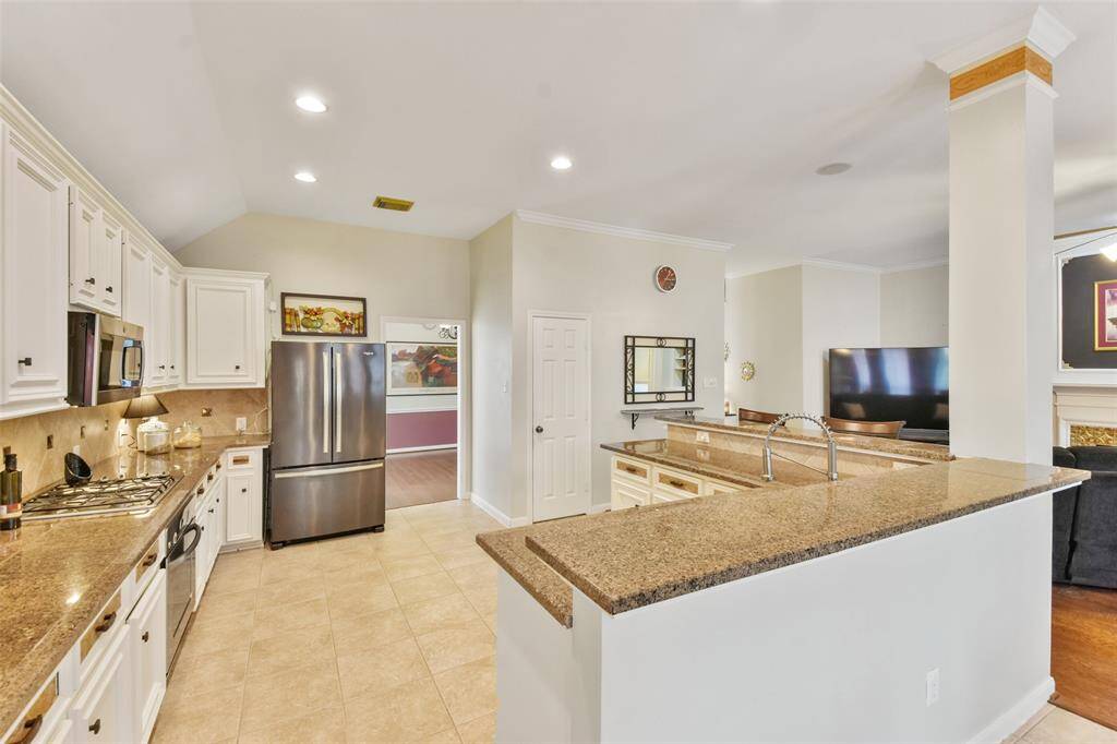 Kitchen offers granite countertops, a wrap around bar, stainless steel appliances, and walk in pantry.