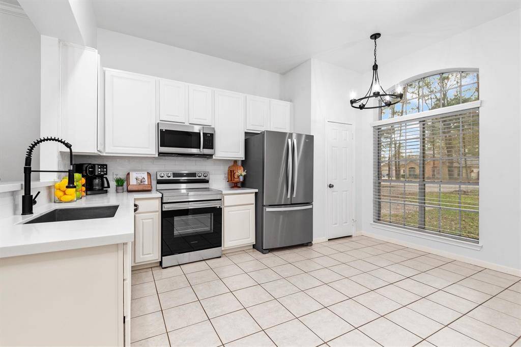 Step into this cozy kitchen, where bright white cabinetry pairs beautifully with sleek quartz countertops, creating an inviting and airy atmosphere. Bathed in natural light, this charming space is both stylish and functional, perfect for cooking and gathering with loved ones.