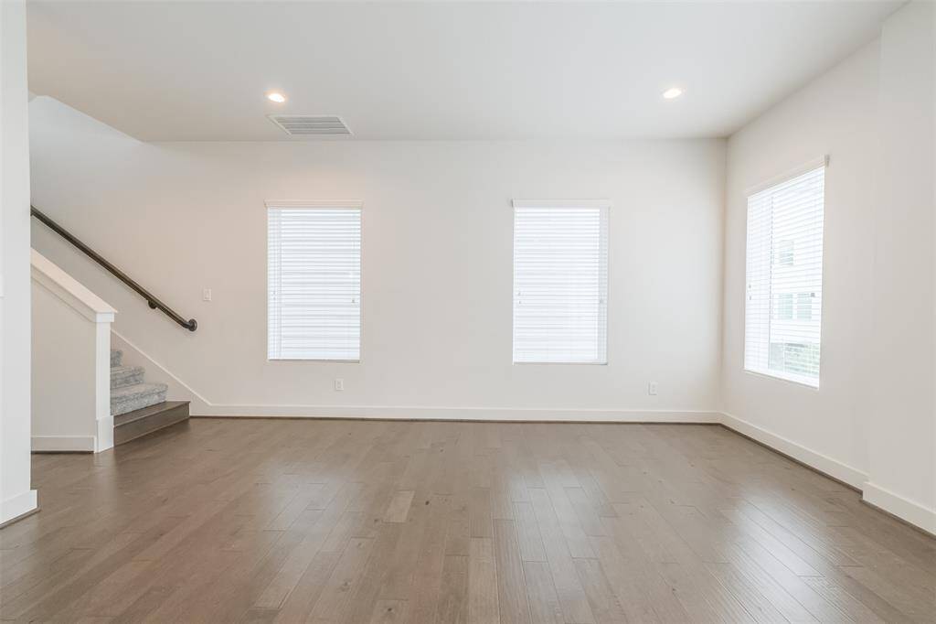 This captivating image showcases the exquisite beauty of engineered wood flooring, adding a touch of elegance to the expansive living and dining room, creating a cozy sanctuary within your home.