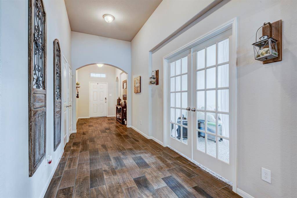 Entryway is decorated with wood look tile, arches, and niches providing character to this floor plan.  The home office is to the right of this picture and has double doors for privacy and provides a quiet place to do homework or worker from home.