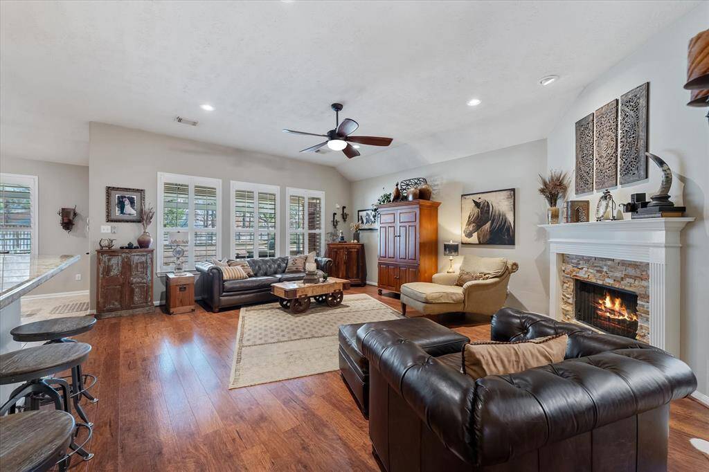 Living room with cozy fireplace and wall of windows to the backyard