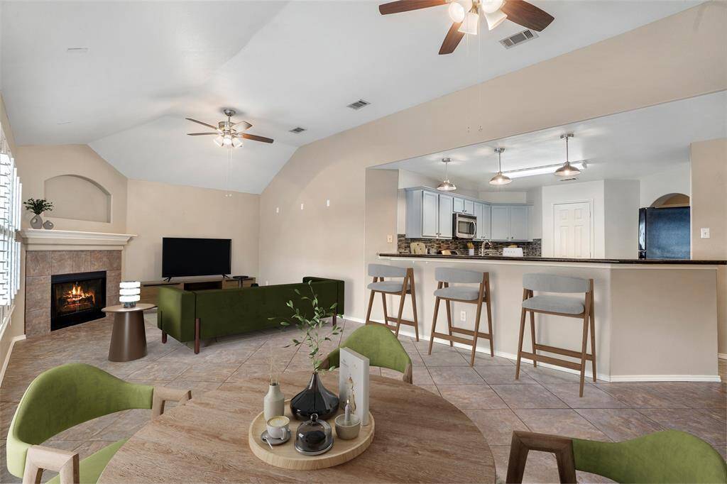 The family room is open to the kitchen and features a gas fireplace and plantation shutters.