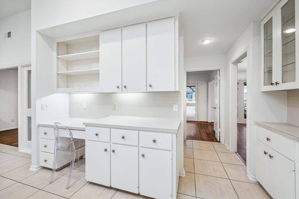 Built-in desk in the kitchen - functional workspace with cabinets, drawers, and open shelves.