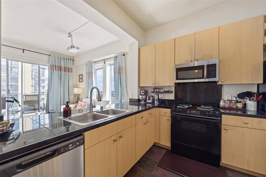 The kitchen is spacious with plenty of counter space and cabinets for storage. Double sinks, stainless appliances, and views from the kitchen make this a lovely space to cook dinner. The range was recently replaced to Stainless Steel (not shown in picture).