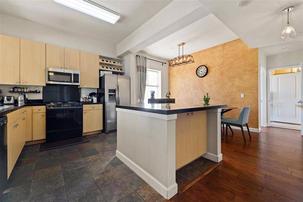 The island in the kitchen is large with granite countertops and additional storage.