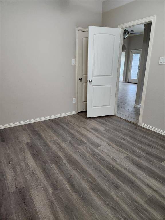 This living room features a spacious and modern design. It has a sleek fireplace, complemented by built-in shelves. Large windows provide ample natural light, and the ceiling fan adds comfort.