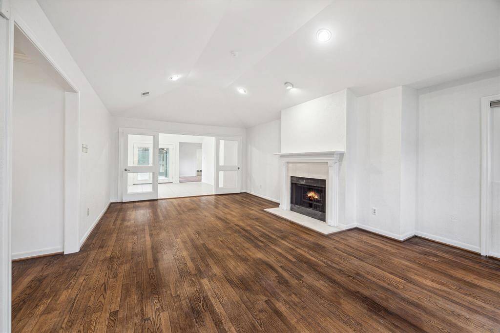 [Living Room] Comfortable formal living room with a view to the front yard. Has French doors for privacy. Recessed lighting. Lots of options for this space - use as a study/playroom or second TV area.