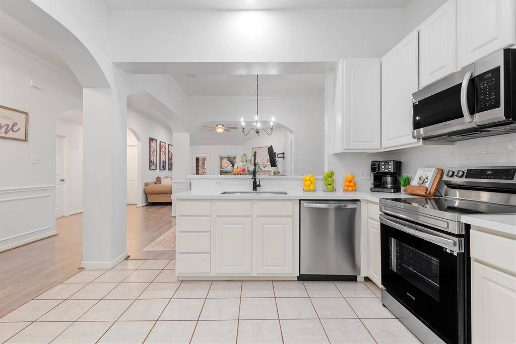 This bright and inviting kitchen seamlessly flows into the family room, creating an open-concept space perfect for entertaining and everyday living. The open floor plan is perfect with the architectural accents of the curved archways.