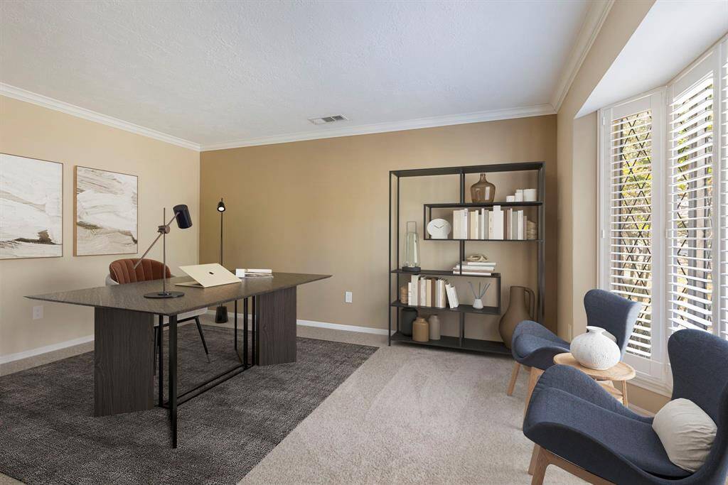 The study has crown moulding and beautiful bay window with a view of the front yard. *This image has been virtually staged.