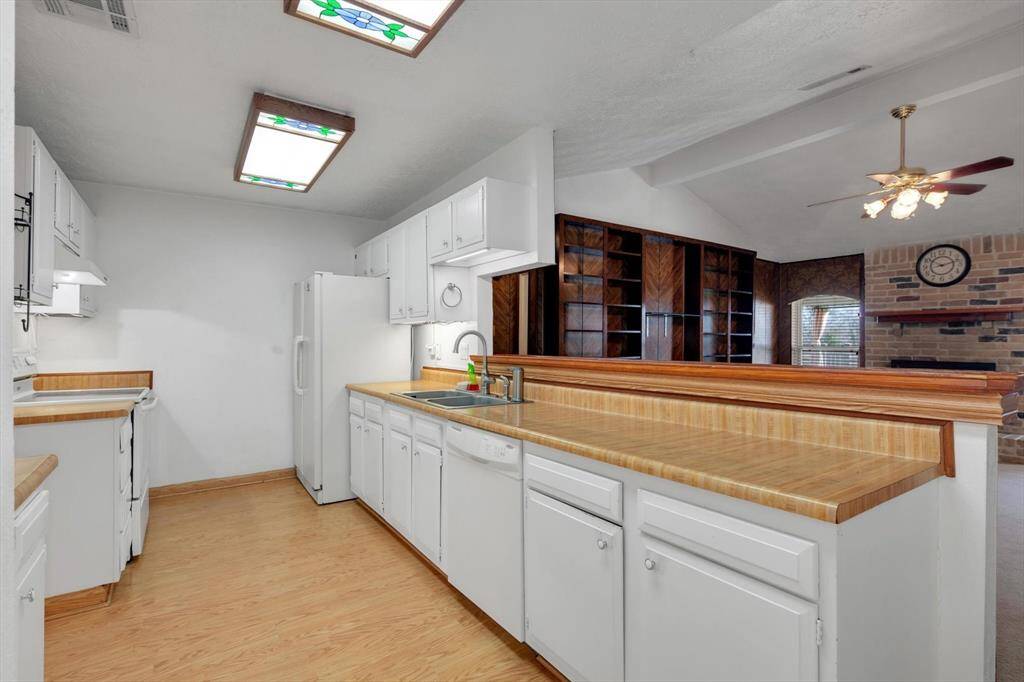 Galley kitchen overlooks living area.