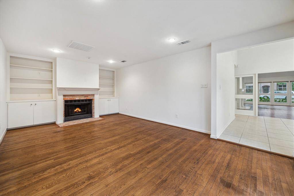 [Family Room] Beautiful space to enjoy conversation with friends and family. Fireplace with mantle has built-ins. Overlooks pool for seamless indoor/outdoor living.