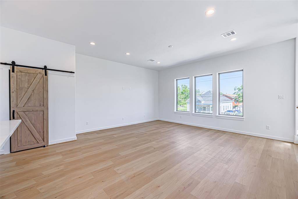 Second floor living room with recessed lighting and high ceilings