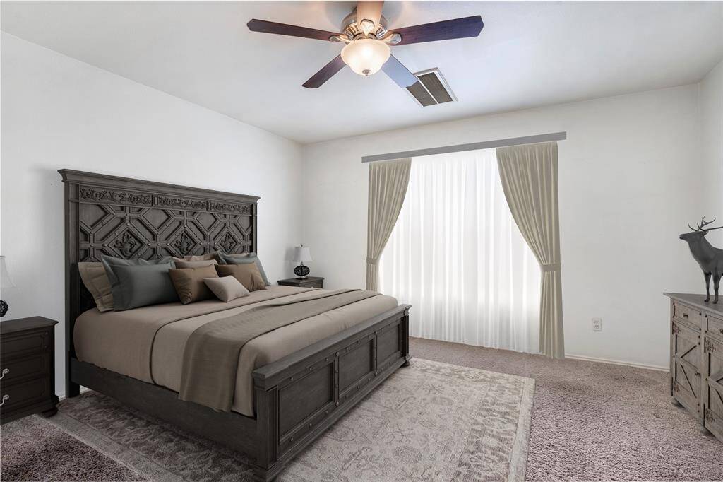 A serene master suite has high ceilings and enough room for a king size bed and large furniture.
