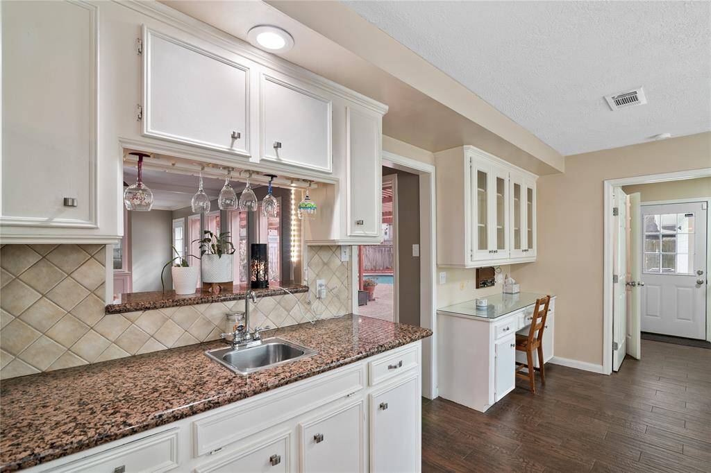 Wet bar area in kitchen with view of utility room in the background.