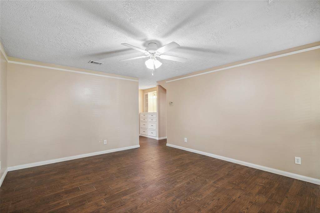 Another view of the master bedroom with built-in dresser visible in the adjoining space, offering extra storage.