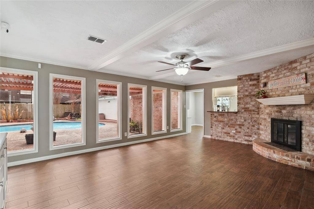 Family room features large windows for lots of natural light creating a welcoming atmosphere, and a view of the pool and patio areas.
