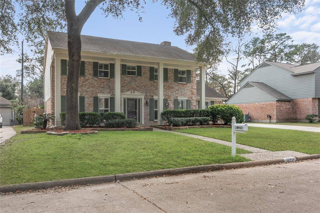 This is a charming two-story brick home with classic colonial features, including large columns and  shutters.