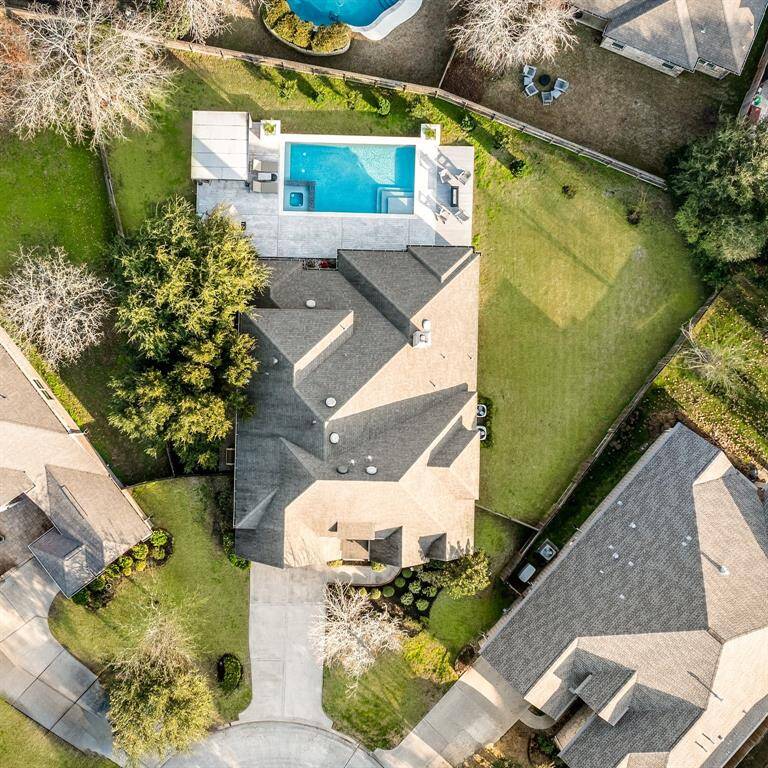 This aerial view showcases a spacious home with a well-maintained lawn and a modern sparkling swimming pool and spa. The property is neatly landscaped and situated in a quiet cul-de-sac, offering privacy and ample outdoor space for relaxation or entertaining.