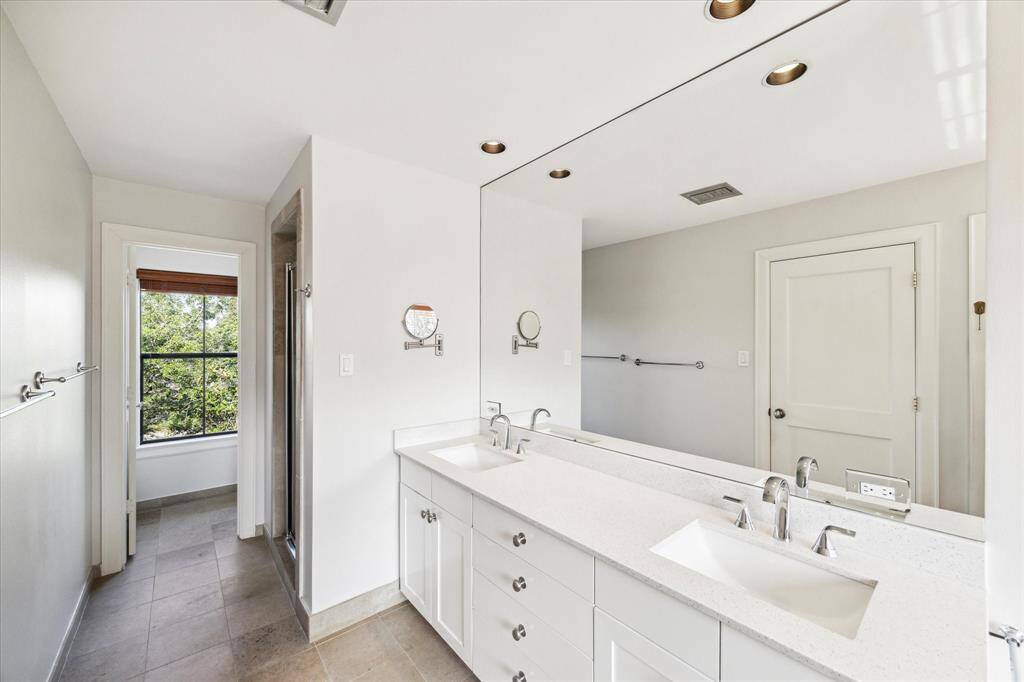 From the primary bathroom looking North. newer dual sinks and under counter storage and linen closet.