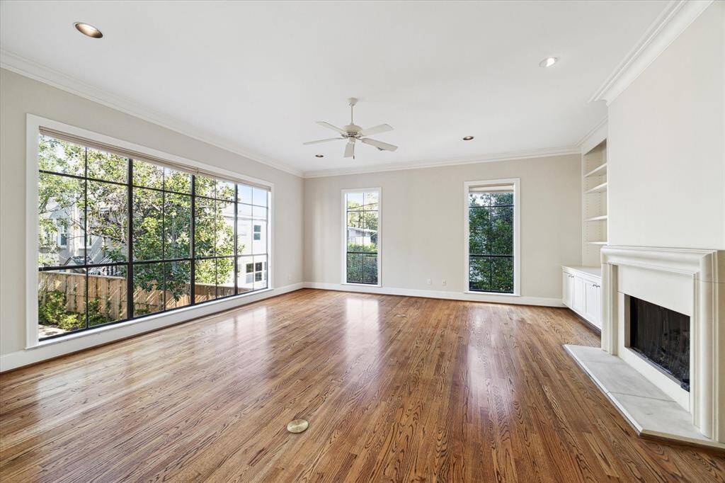 Beautiful hardwood flooring, lots of natural light, crown molding, wall of bookshelves and gas log fireplace create and inviting living and entertaining space.