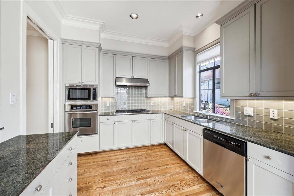 Efficient kitchen with stainless appliances, under-counter lighting and granite counter tops.