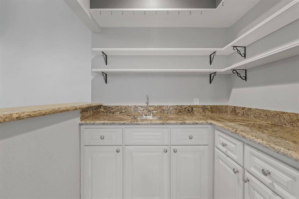 Wet Bar area with shelving and cabinets features granite counters.