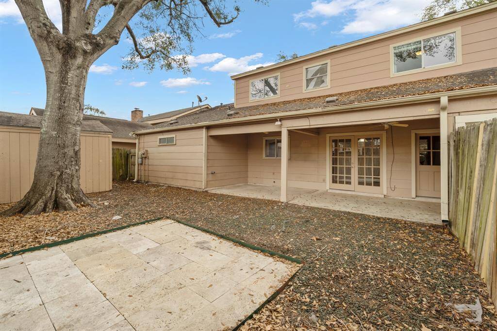 View of covered back patio, storage shed and backyard area.
