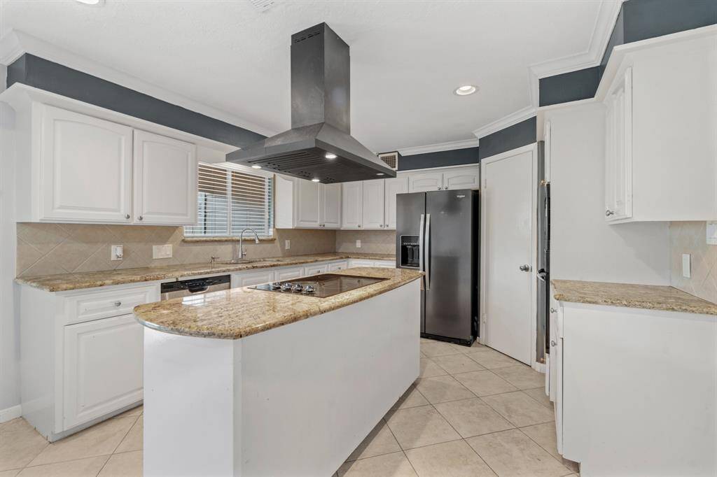 Electric island cooktop kitchen features granite counters, plenty of cabinet space, walk-in pantry and tile floor.