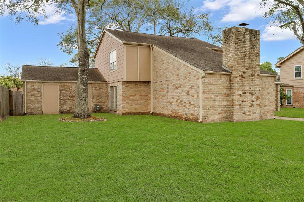 Front lawn view has mature oak trees.