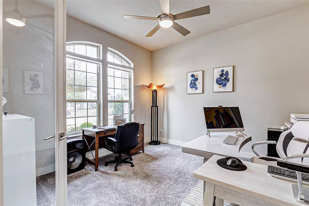 Bright and inviting home office with large windows allowing ample natural light. Ceiling fan for your convenience and it is located right at the entrance of the home