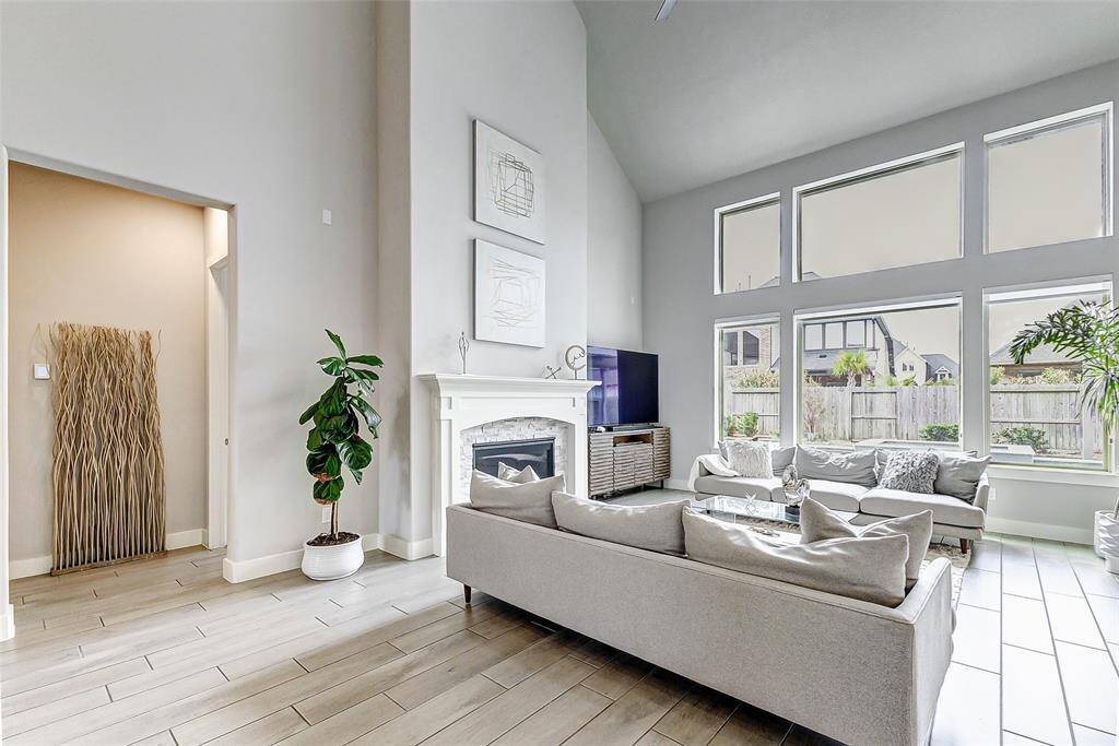 Modern fireplace, neutral tones, and stylish decor, creating a welcoming and airy atmosphere in your living room. Great for gathering and entertaining