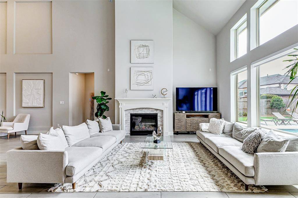 Cozy fireplace, modern decor, and a stylish seating arrangement, offering a bright and inviting atmosphere.