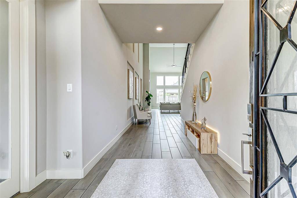 Bright and welcoming entryway with high ceilings and modern decor, leading to a spacious living area filled with natural light.