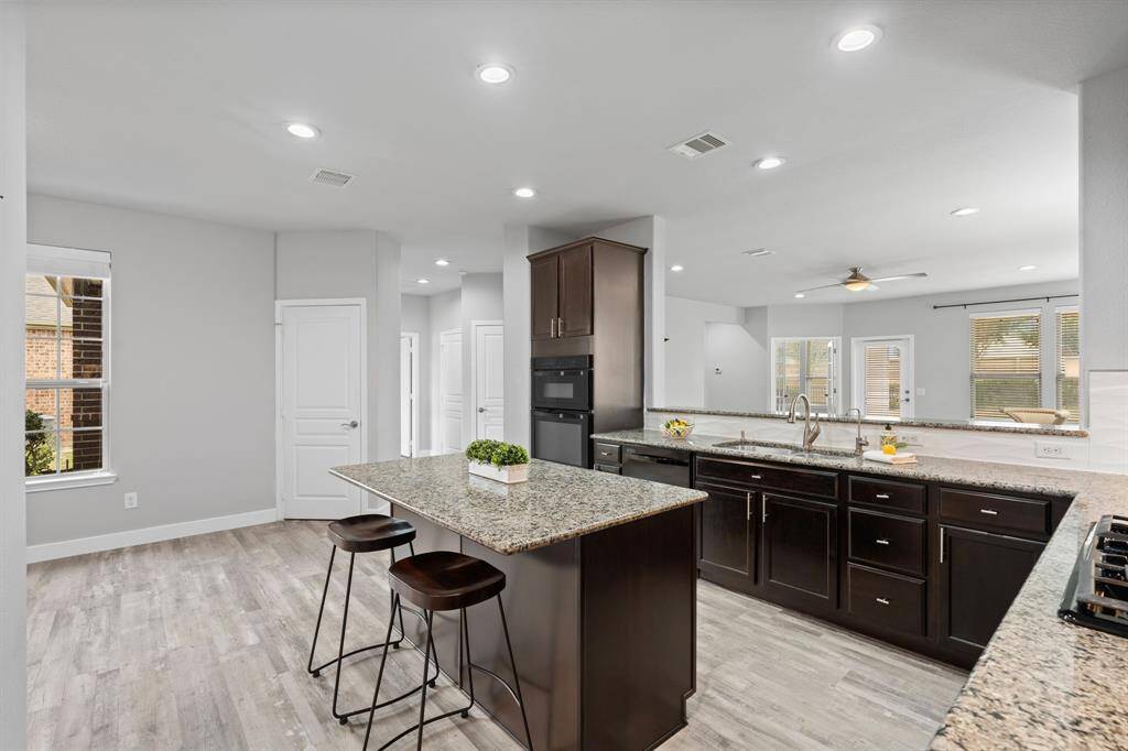 Large kitchen is well-suited for both cooking & entertaining. The bar offers additional seating, making it a focal point for gatherings and meal preparation.