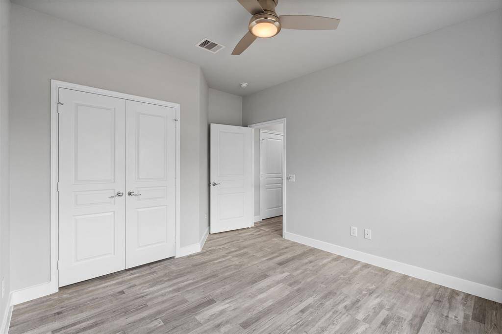 Another view of guest bedroom with double doors to closet space.
