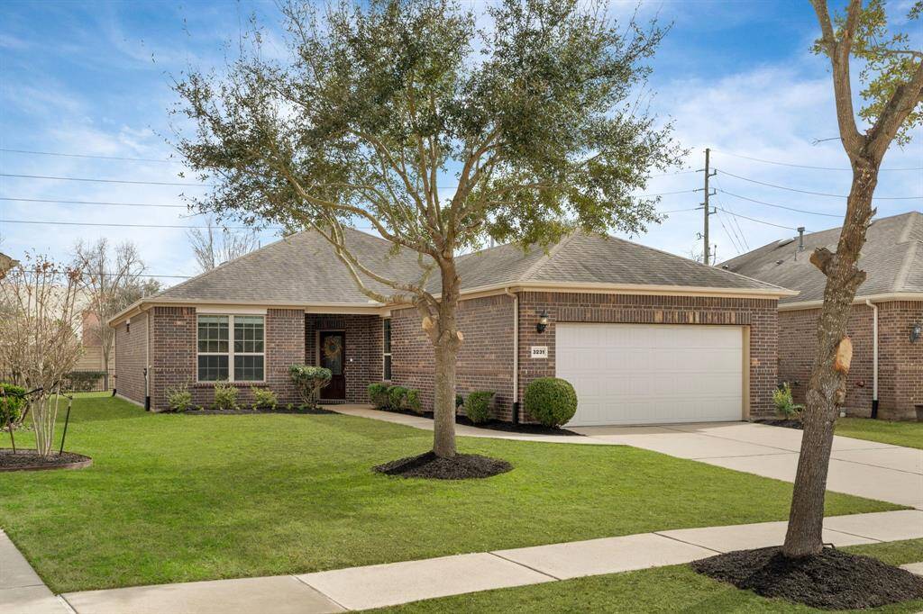 This charming dark brick home boasts an inviting entrance, complemented by neatly trimmed shrubs and a decorative glass front door that welcomes natural light inside. Situated on a spacious lot on a quiet street, it offers added privacy with more room between homes. With its classic curb appeal and timeless design, this home is a true gem. New grass will be installed later this month as the weather improves. Photo has been digitally enhanced.