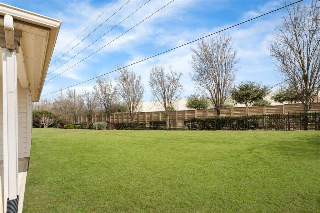 Mature trees in the green space behind the property create an ideal setting for outdoor activities. The area is bordered by a tall privacy fence, ensuring seclusion.